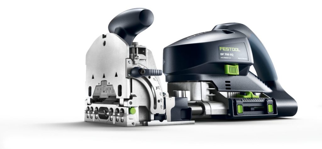 Elektronarzędzie Festool Domino DF 700 EQ do łączenia elementów drewnianych. Widok z boku, pokazujący metalową podstawę, pokrętło regulacji głębokości i uchwyt.