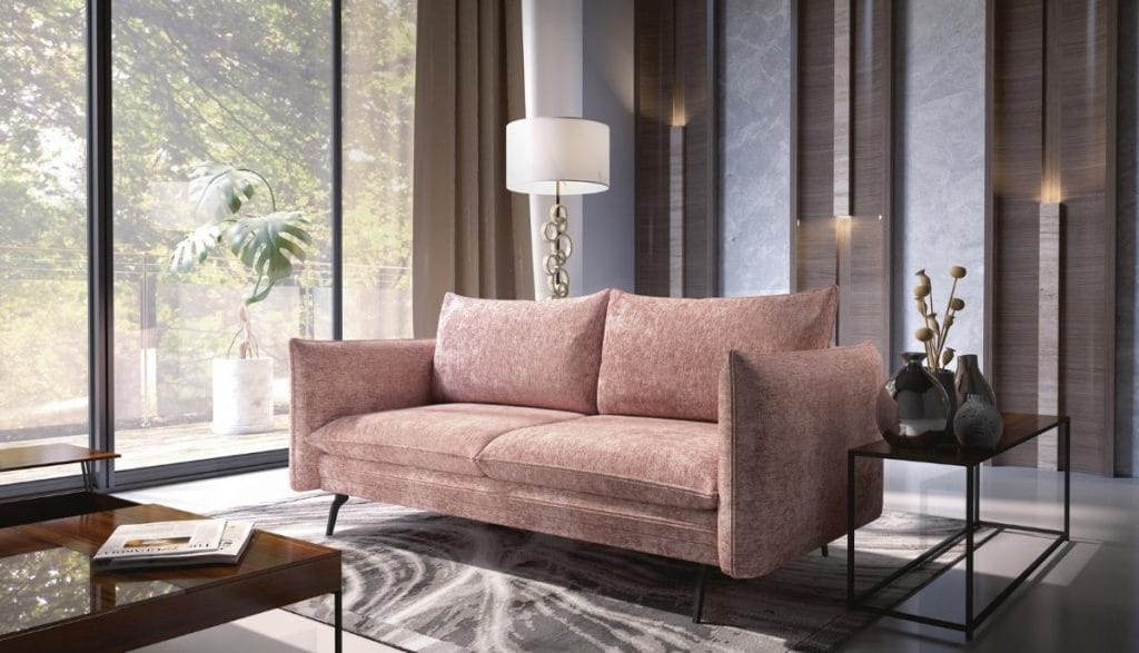 Elegancka brudnoróżowa sofa do salonu Akita 3FBA ustawiona w nowoczesnym wnętrzu przy dużym oknie.
