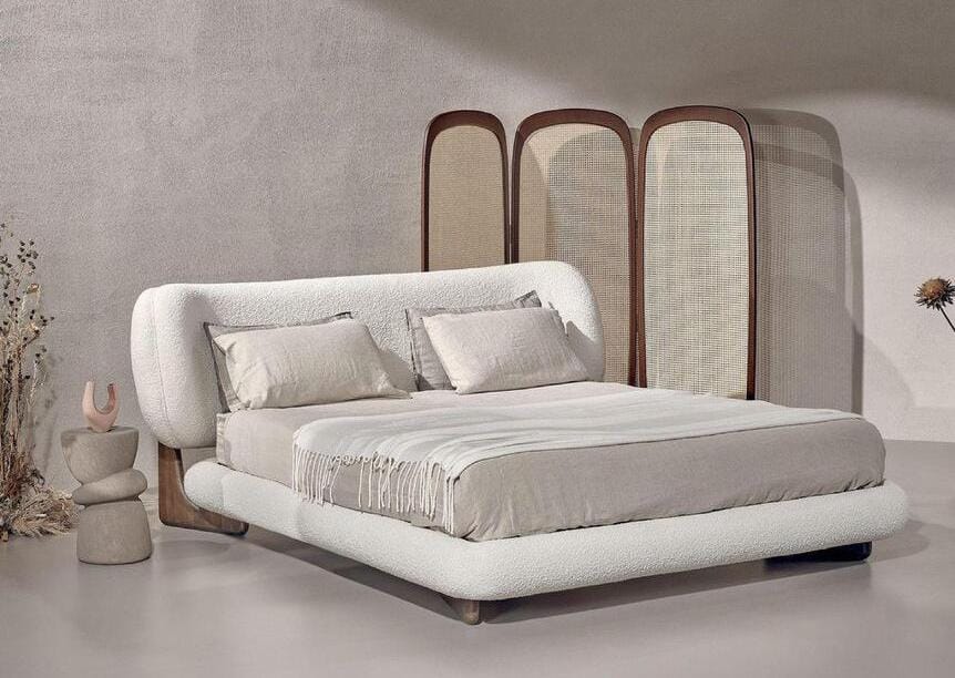 Łóżko Lily od marki Interno Italiano, której salon znajduje się na terenie Galerii Wnętrz DOMAR, wprowadza do sypialni ciepło i atmosferę intymności dzięki swoim miękkim, otulającym liniom. Zaokrąglona drewniana podstawa oraz płynnie wyprofilowane, tapicerowane wezgłowie tworzą formę, która wykracza poza funkcję użytkową – staje się przyjemnym, zmysłowym doświadczeniem sprzyjającym odpoczynkowi. Model dostępny jest w eleganckiej tapicerce skórzanej, nubukowej lub wykonanej z wysokiej jakości tkaniny.