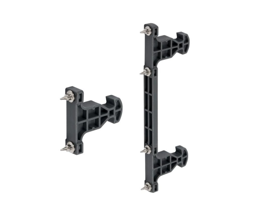 Szare plastikowe znaczniki AMIX z metalowymi kolcami, służące do precyzyjnego wyznaczania punktów montażowych frontów szuflad.