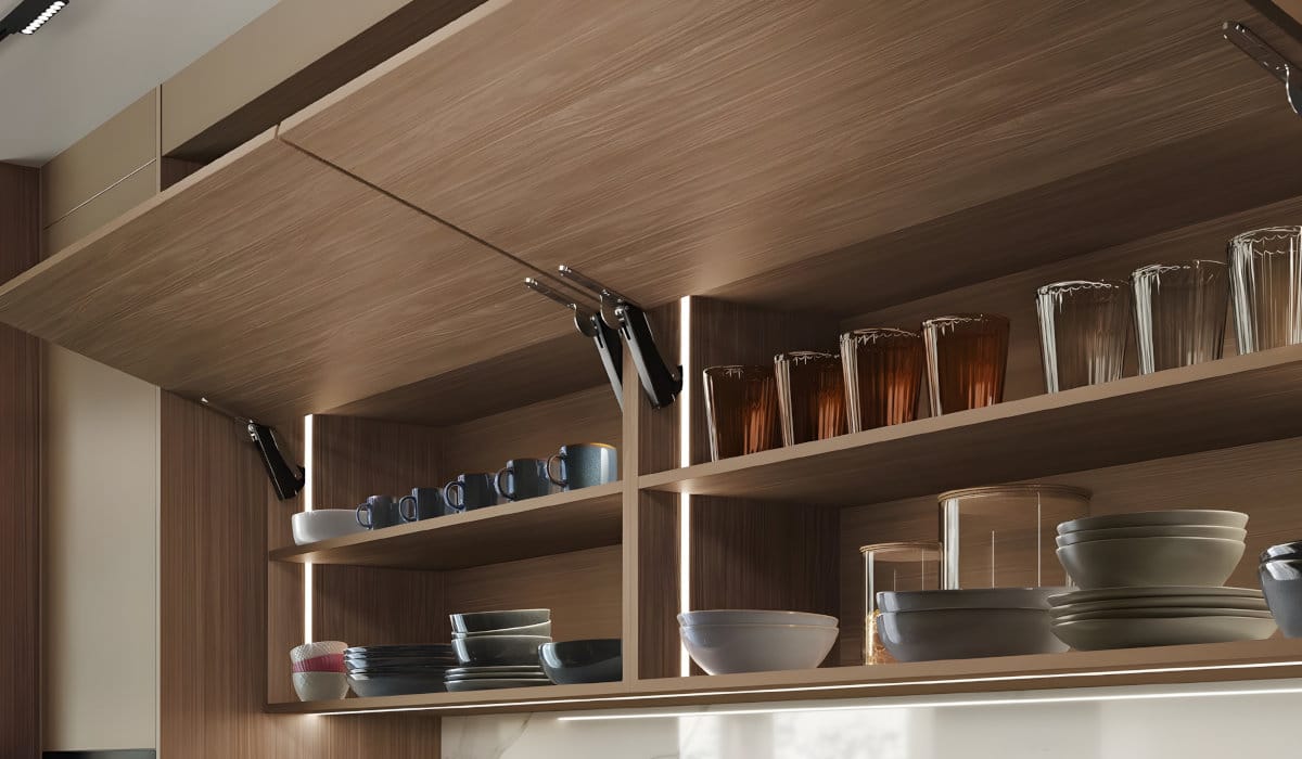 Drewniane szafki kuchenne z systemem bezuchwytowego otwierania Häfele Free Space. Widoczne otwarte fronty typu klapa z dyskretnym mechanizmem podnośnika i podświetleniem LED wnętrza szafek.