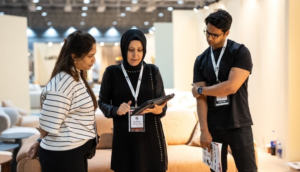 Trzy osoby rozmawiają na stoisku podczas Hive Furniture Show Sharjah – prezentacja produktów i rozmowy branżowe.