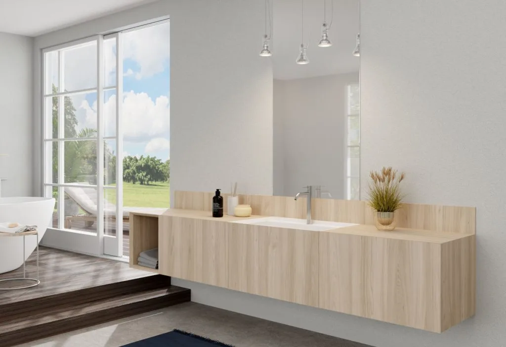 Podwieszana szafka łazienkowa zintegrowana z umywalką, wykończona jasnym, naturalnym dekorem drewna Interprint Helia. Minimalistyczny design łazienki z widokiem na taras, utrzymany w jasnej, skandynawskiej kolorystyce.