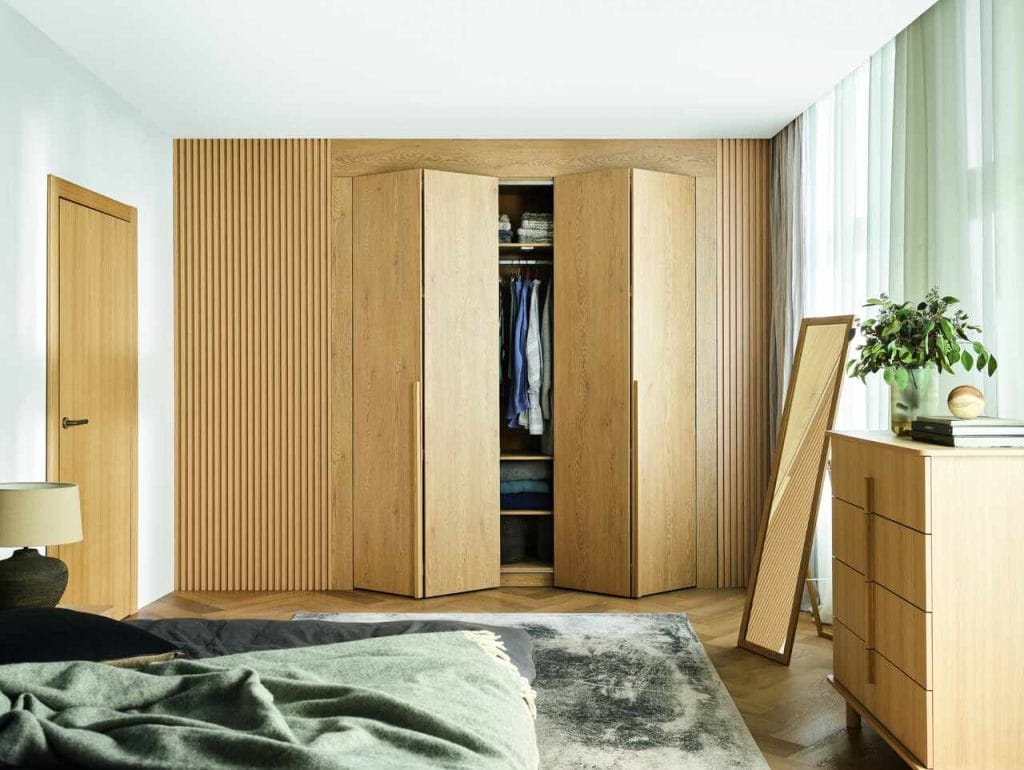 Szafa Stor marki Wnętrza VOX, której salon znajduje się na terenie Galerii Wnętrz DOMAR, to praktyczne i eleganckie rozwiązanie, które z powodzeniem zastąpi zabudowę stolarską, oferując pełną funkcjonalność bez długiego oczekiwania. Model o szerokości 160 cm zapewnia wygodne przechowywanie dla dwóch osób, a dzięki przesuwnym i składanym drzwiom z cichym domykiem umożliwia swobodny dostęp do całej zawartości, jednocześnie oszczędzając miejsce w pomieszczeniu. Wbudowane oświetlenie LED z czujnikiem ruchu ułatwia korzystanie z garderoby nawet po zmroku, bez konieczności zapalania głównego światła. Wnętrze szafy można dopasować do swoich potrzeb, wybierając jeden z gotowych pakietów wyposażenia lub rozszerzając je o dodatkowe półki, drążki czy akcesoria. Różne warianty uchwytów pozwalają nadać garderobie indywidualny charakter, a regulowane stopki ułatwiają idealne wypoziomowanie mebla. Garderoba Stor dostępna jest w kilku wysokościach i szerokościach, dzięki czemu można tworzyć większe zabudowy. Dzięki panelom maskującym świetnie wpisuje się również we wnęki, umożliwiając uzyskanie estetycznego efektu szafy na wymiar.