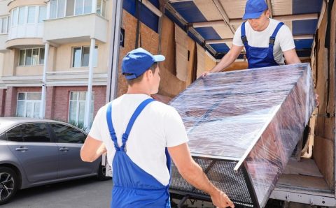 Planowanie tras w branży meblarskiej: pracownicy ładujący zabezpieczone meble do transportu