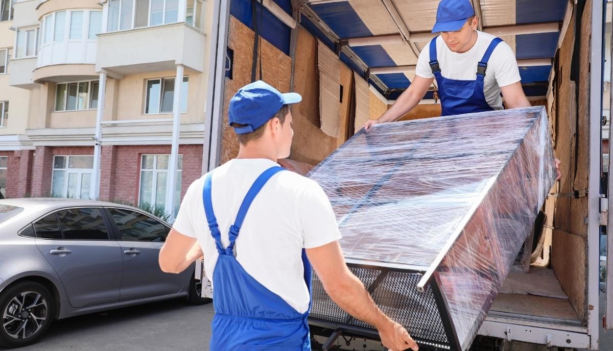 Planowanie tras w branży meblarskiej: pracownicy ładujący zabezpieczone meble do transportu