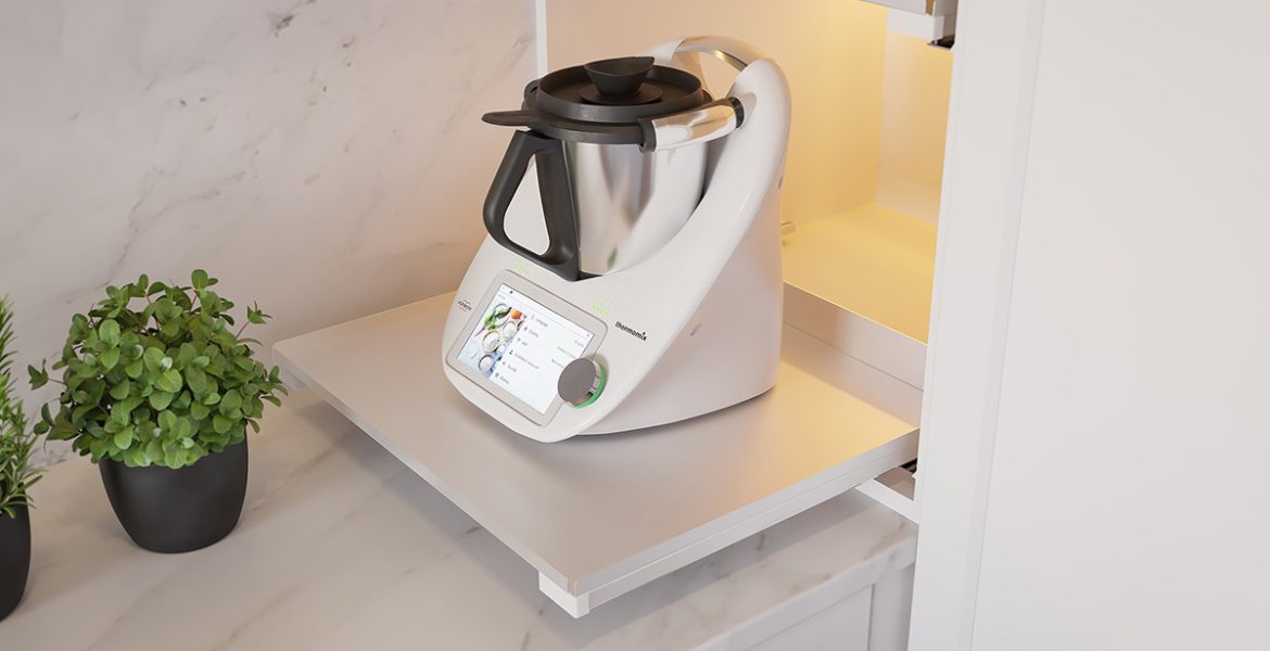 Detaliczny widok wewnętrznej wysuwanej półki REJS Puro w jasnym wykończeniu, z postawionym robotem kuchennym Vorwerk Thermomix i ziołami, na tle marmurowego blatu.