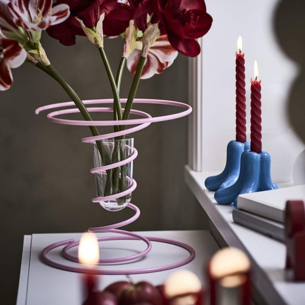 W zimowej kolekcji IKEA VINTERFINT 2025 niemal całą uwagę skradł wazon. Jego sprężynowa, metalowa konstrukcja skrywa szklaną wkładkę. Nieoczywista forma łączy w sobie lekkość, funkcję i humor. Spiralna rama podtrzymuje kwiaty, jednocześnie nadając całości dynamiczny charakter. [[Okrągła forma nie ma końca, co daje przedmiotowi więcej życia. Ten wazon jest tego przykładem – jego kształt jest nieprzerwany, a przy tym wnosi element zabawy dzięki swojej sprężystości. To połączenie dwóch części, które pozornie nie potrzebują siebie nawzajem, a jednak razem tworzą pełnię – jak dwie części układanki]] – wyjaśnia Gustaf Westman. Fot. Biuro prasowe IKEA Polska.