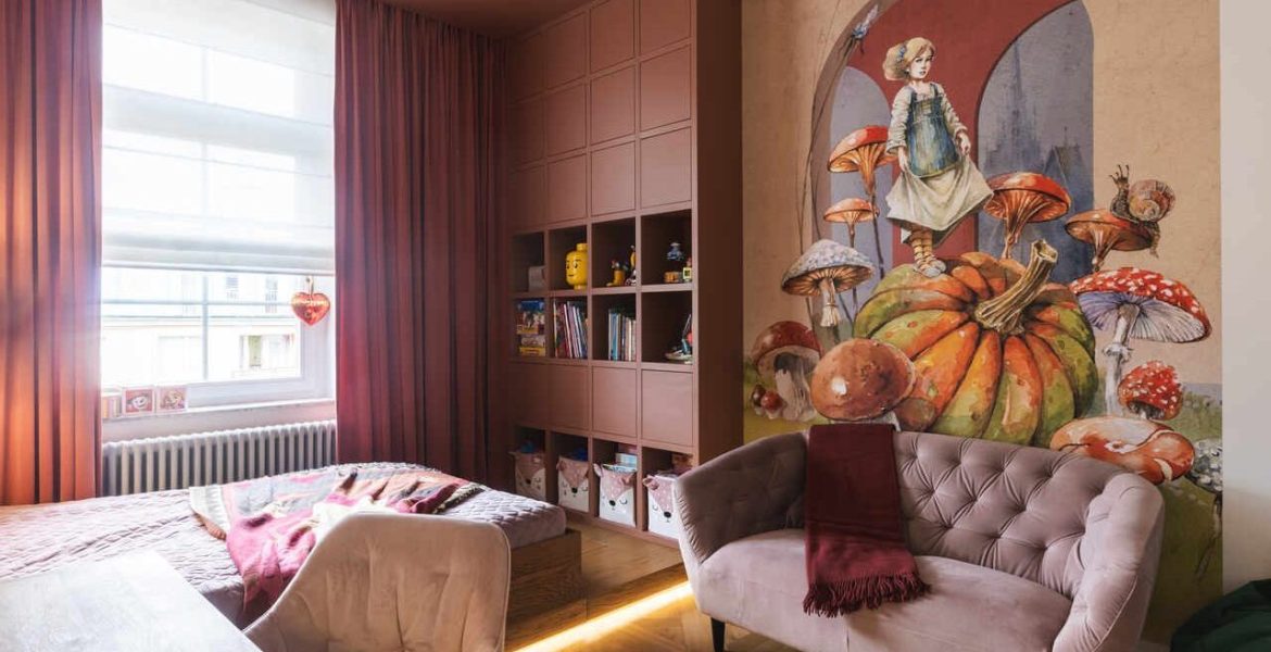 Monochromatyczny pokój dziecięcy w odcieniach brudnego różu i terakoty projektu masz.design. Malarski mural z motywem baśniowych grzybów nadaje wnętrzu głębi, a drewniany podest z podświetleniem LED subtelnie wydziela strefę wypoczynkową. Fot. Adam Burdyło, materiały prasowe Rubio Monocoat.