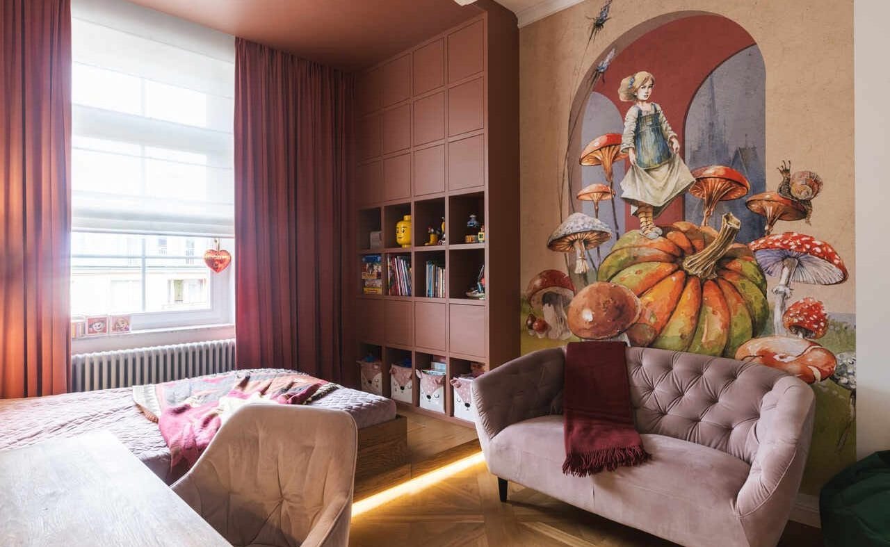 Monochromatyczny pokój dziecięcy w odcieniach brudnego różu i terakoty projektu masz.design. Malarski mural z motywem baśniowych grzybów nadaje wnętrzu głębi, a drewniany podest z podświetleniem LED subtelnie wydziela strefę wypoczynkową. Fot. Adam Burdyło, materiały prasowe Rubio Monocoat.