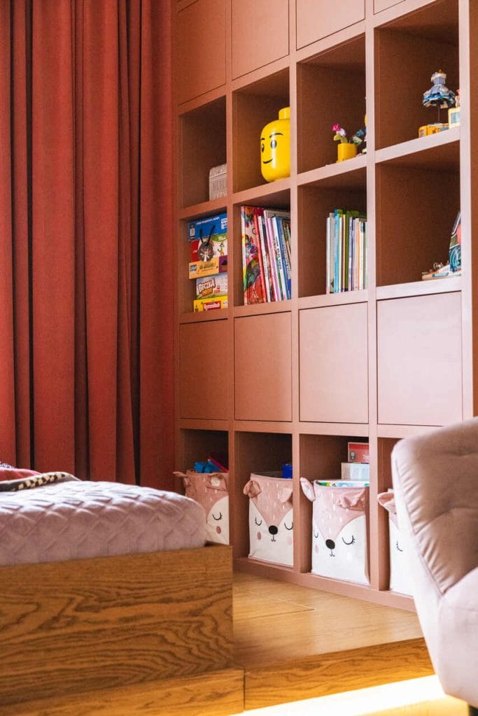 Detal funkcjonalnej zabudowy garderobianej i regału na zabawki w projekcie masz.design. Ciepłe odcienie drewna olejowanego systemem Rubio Monocoat idealnie korespondują z matowym wykończeniem frontów. Fot. Adam Burdyło, materiały prasowe Rubio Monocoat.