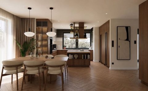 Jadalnia z orzechowym stołem i tapicerowanymi krzesłami Calligaris, otwarta na kuchnię. Projekt Filipa Kierasa i Bartosza Młynarskiego z pracowni Tomato Studio.