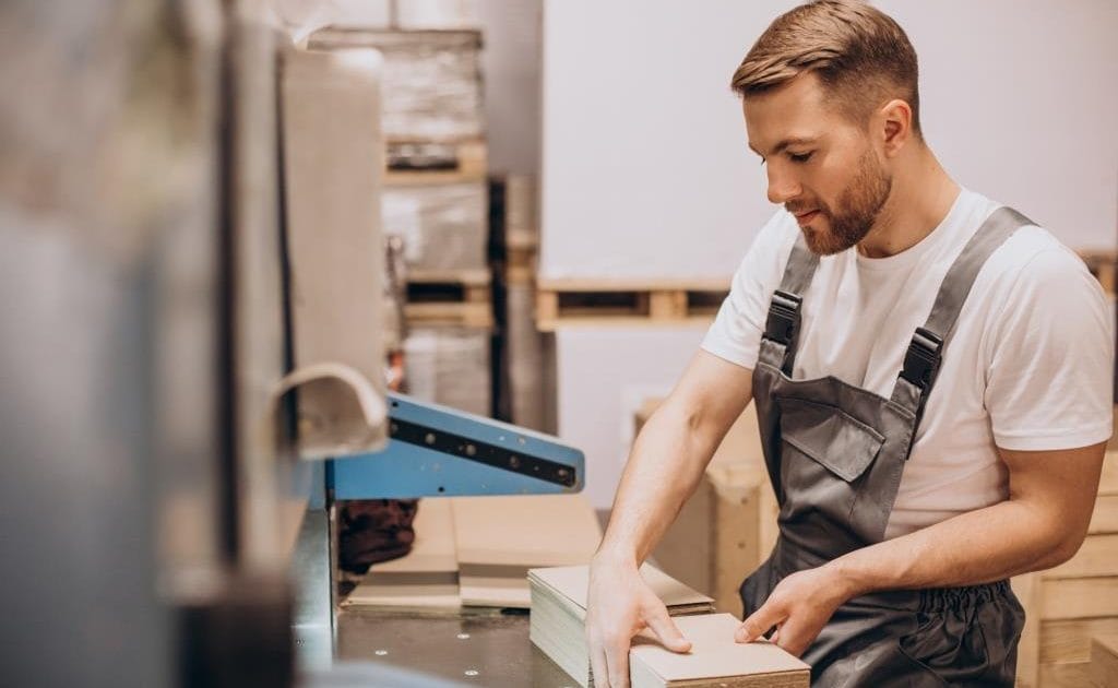 Mężczyzna pracujący przy produkcji mebli. Fot. senivpetro / magnific.