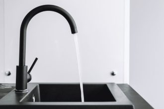 Sposób na oszczędzanie wody przy umywalce: nowoczesna, czarna bateria z oszczędnym strumieniem wody