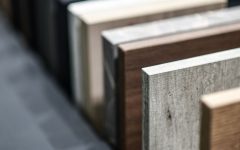 Wzorniki obrzeża RAUKANTEX marki REHAU w różnych dekorach, w tym drewnopodobnych i betonowych, prezentujące szeroką ofertę dla nowoczesnego stolarstwa.