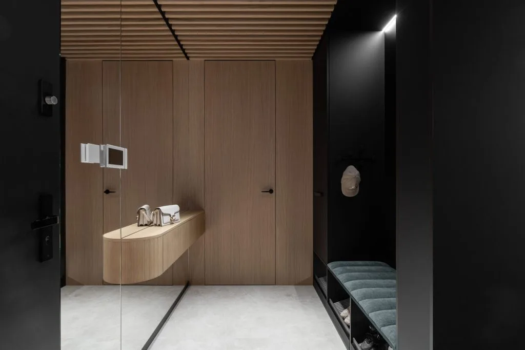 Apartament o pow. 180 m2 dla rodziny 2+3 w Gdańsku. Wejście do mieszkania z siedziskiem i szafami. W dalszej części korytarza szafa z miejscem na robota sprzątającego oraz schowek z miejscem na kuwetę dla kota. Wszystko ukryte za frontami meblowymi, aby tworzyło integralną część z zabudową. Proj. arch. Anna Maria Sokołowska, Anna Maria Sokołowska Architektura Wnętrz. Fot. Fotomohito Katarzyna Seliga-Wróblewska i Marcin Wróblewski.