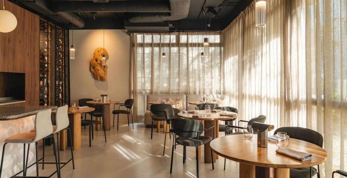 Studio Rysik stworzyło dla restauracji Bez Gwiazdek w sercu Powiśla przestrzeń pełną harmonii i spokoju. Naturalny len w oknach i szklanych przegrodach delikatnie filtruje światło, odcinając gości od zgiełku ulicy Wiślanej i wprowadzając ich w nastrojową strefę barw ziemi. Fot. Anna Gudaniec.