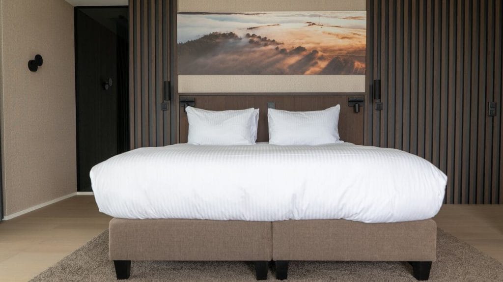 W hotelu Anatura w Luksemburgu każdy detal wyposażenia – od szafek nocnych po ścienne panele przy łóżku – bazuje na dekorach Master Oak od Unilin Panels. Dzięki głębi usłojenia powierzchnia oddziałuje na zmysły dotyku i wzroku. Fot. materiały Unilin Panels.