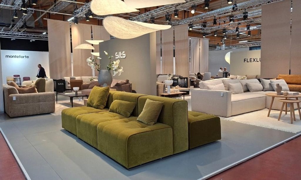 ALT: Oliwkowa sofa modułowa i jasny narożnik na stoisku targowym SITS na M.O.W. 2026.