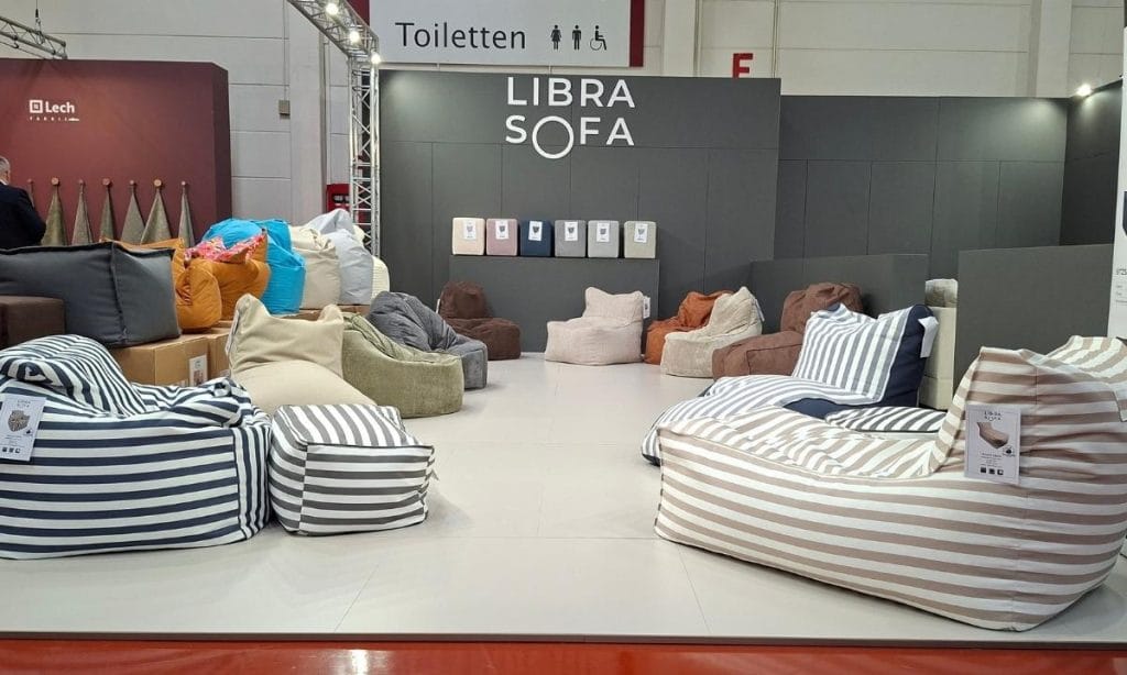 Kolorowe pufy i miękkie fotele worki sako w paski na stoisku Libra Sofa podczas targów M.O.W. 2026.