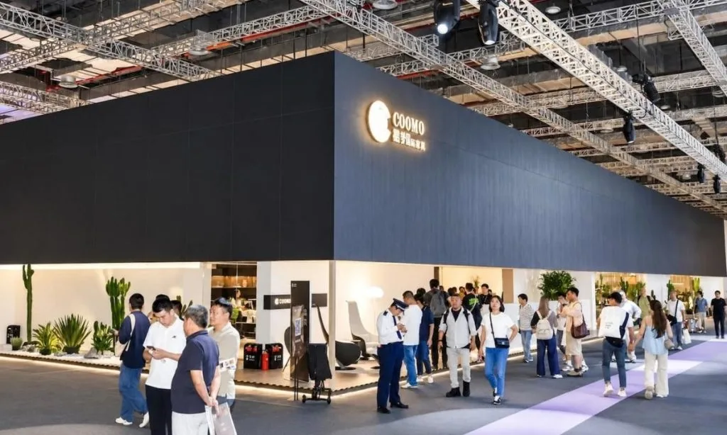 Ciemne, minimalistyczne stoisko marki COOMO z żywą roślinnością na CIFF Shanghai – branżowe targi meblowe w Chinach.