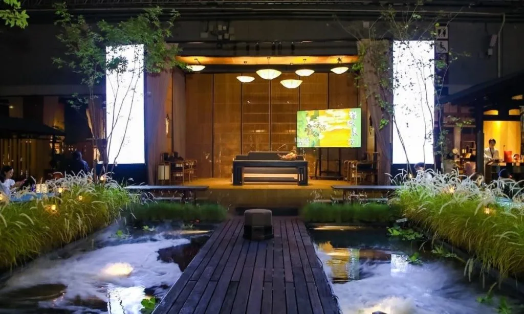 Scenograficzny pawilon herbaciany usytuowany nad wodą z mgłą w ramach instalacji A View of Tea Classics – targi meblowe w Chinach CIFF Shanghai.